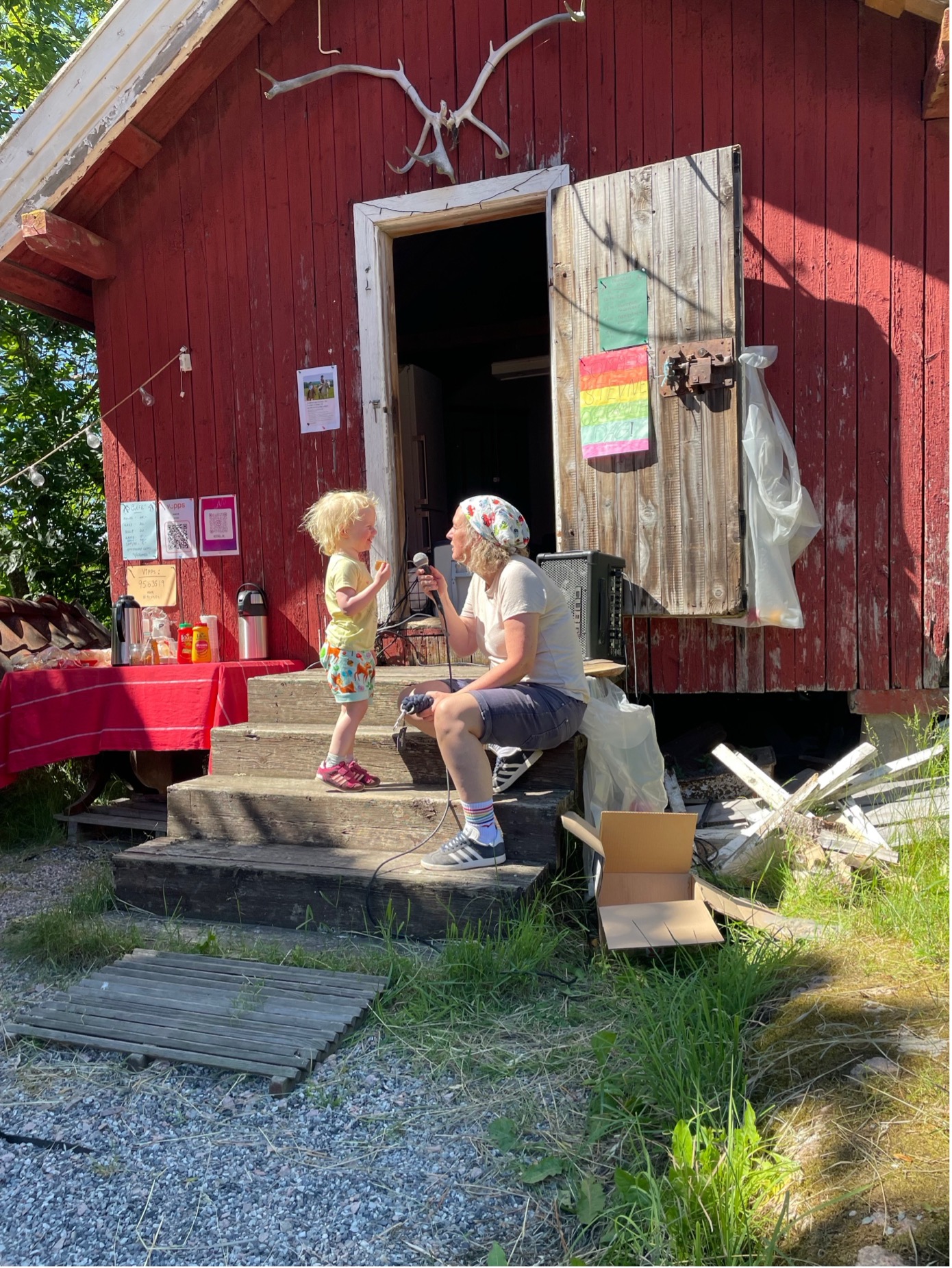 Barn og voksen på trappa til den røde salgsboden under familiedagen