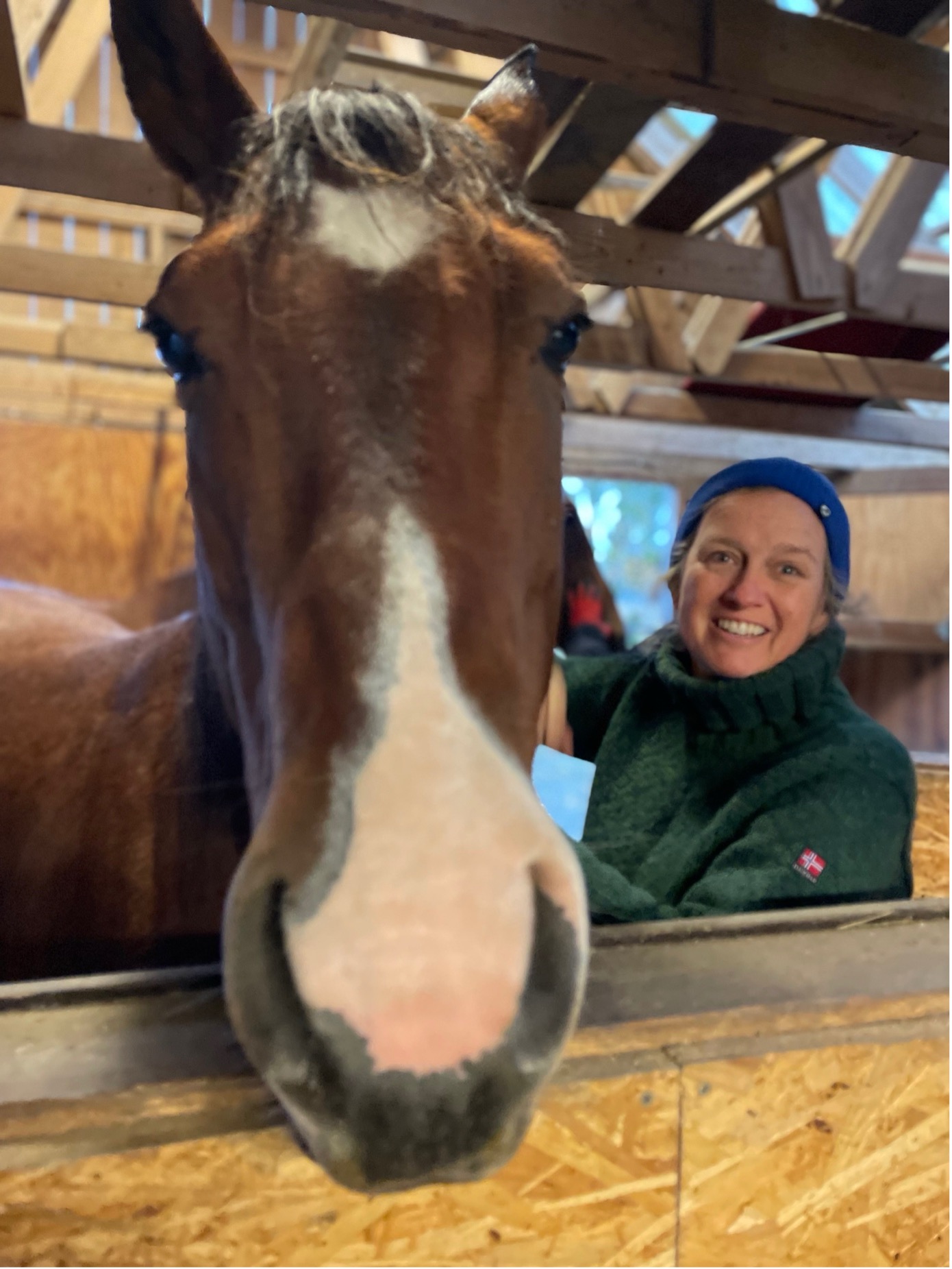 Anne Borchgrevink sammen med en hest i stallen