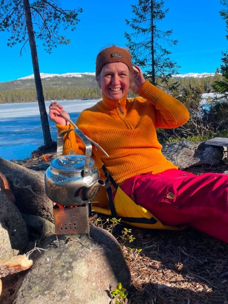 Anne Borchgrevink med kaffekjelen på bålet ved vannet